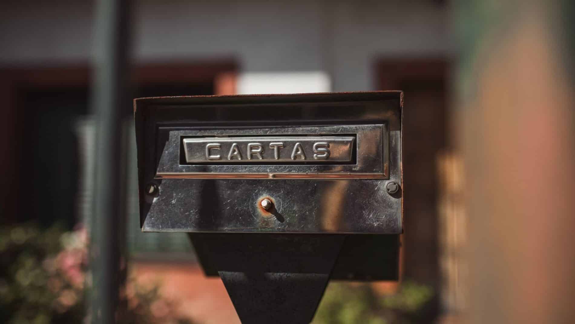 Close-up of an outdoor mailbox with 'Cartas' label in a sunny setting.